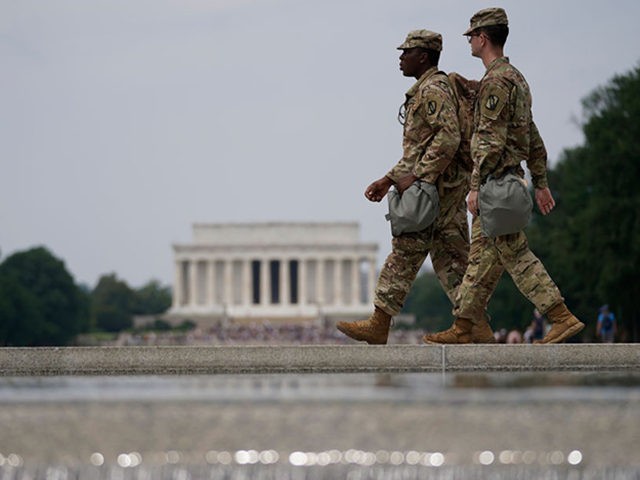 WASHINGTON, DC - JUNE 06: Two members of the National Guard walk past at the World War II Memorial as protests against police brutality and racism take place on June 6, 2020 in Washington, DC. This is the 12th day of protests with thousands of people descending on the city …