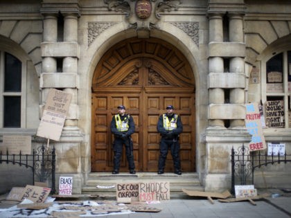 OXFORD, ENGLAND - JUNE 09: Police officers stand guard outside University of Oxford's Oriel College during a protest by the Rhodes Must Fall campaign on June 09, 2020 in Oxford, England. The Rhodes Must Fall campaign protests outside University of Oxford's Oriel College where a statue of imperialist Cecil John …