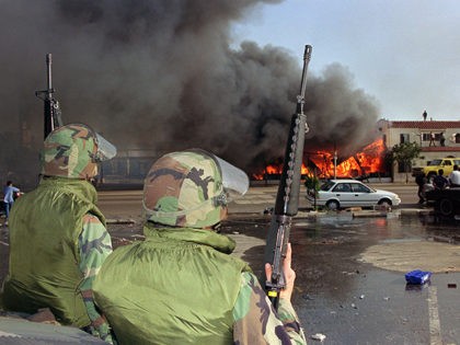 National Guardsmen watch a business go up in flames in South Los Angeles, 30 April 1992. T