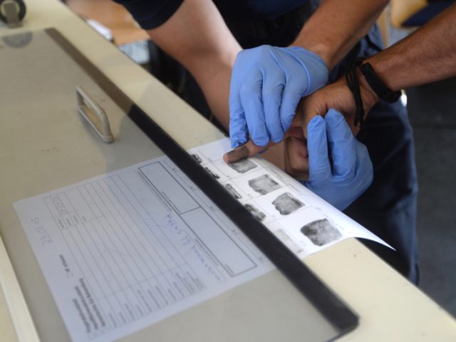 Fingerprints are taken of refugees as they are processed at the first registration point o