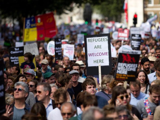 Demonstrators hold placards as the take part in a pro-refugee rally in central London on S