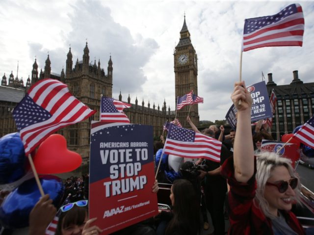 Activists wave US flags as they ride on a "Stop Trump" battle bus as they approach the Houses of Parliament in London on September 21, 2016 in a campaign run by campaign group Avaaz to mobilise US expatriots in the UK to register to vote in the US presidential election. …