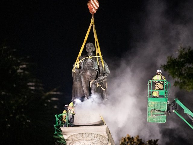 CHARLESTON, SC - JUNE 24: A worker uses a saw at the foot of the statue of John C. Calhoun atop the monument in his honor at Marion Square on June 24, 2020 in Charleston, South Carolina. Work crews began dismantling the monument in Tuesday evening. (Photo by Sean Rayford/Getty …