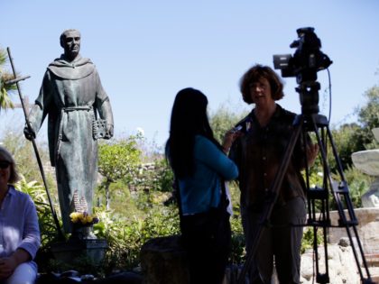 File - In this Sept. 23, 2015 file photo, an interview is conducted next to a statue of Junipero Serra at the Carmel Mission in Carmel-By-The-Sea, Calif. Northern California's Stanford University has announced it will drop the name of a controversial 18th century Spanish priest from two dormitories and its …