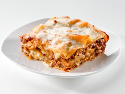 freshly baked lasagna piece on white plate close-up