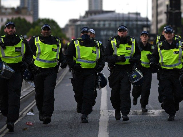 Police officers runs across Waterloo Bridge to reinforce colleagues on the Strand after protesters supporting the Black Lives Matter movement clash with opponents in central London on June 13, 2020, in the aftermath of the death of unarmed black man George Floyd in police custody in the US. - Police …