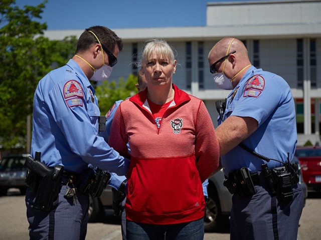 A protester from a grassroots organization called REOPEN NC is arrested after refusing to