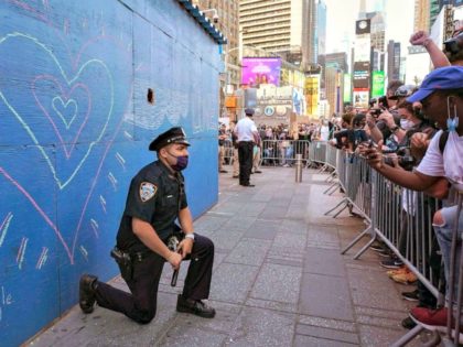 A New York City police officer takes a knee during a demonstration by protesters in Times Square over the death of George Floyd at a rally on May 31, 2020 in New York.A New York City police officer takes a knee during a demonstration by protesters in Times Square over …