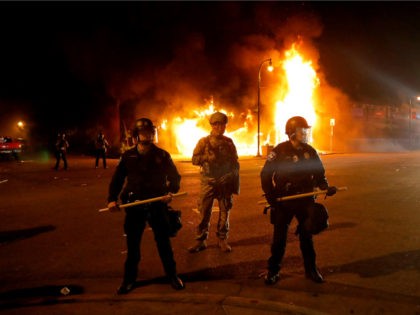 Minneapolis Police keep protesters back near a structure fire, Saturday, May 30, 2020, in Minneapolis. Protests continued following the death of George Floyd, who died after being restrained by Minneapolis police officers on Memorial Day. (AP Photo/Julio Cortez)