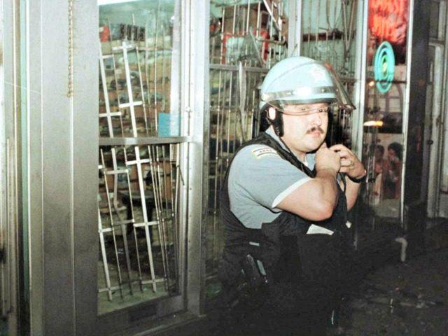 CHICAGO, IL - JUNE 16: A Chicago policeman stands outside a looted appliance store after g