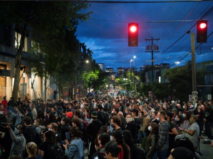 People listen as a band plays a free show in front of the Seattle Police Departments East Precinct in the so-called "Capitol Hill Autonomous Zone" on June 10, 2020 in Seattle, Washington. The zone includes the blocks surrounding the Seattle Police Departments East Precinct, which was the site of violent …