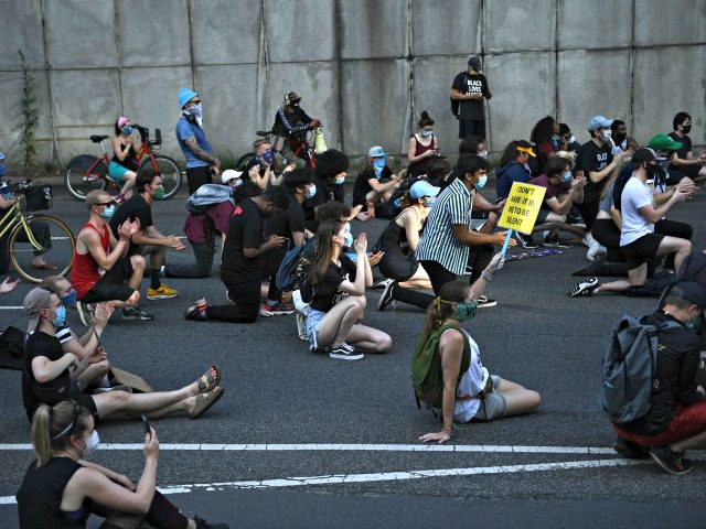 Demonstrators sit on a highway to block it, as protests triggered by the death of George F
