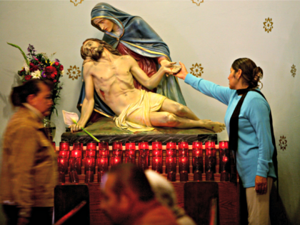 SAN DIEGO - APRIL 16: A church congregant touches a statue of Jesus and Mary during Easter Mass at Our Lady of Guadeloupe Catholic Church April 16, 2006 in the Barrio Logan section of San Diego, California. (Photo by Sandy Huffaker/Getty Images)