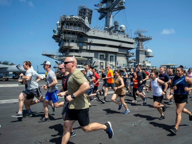 In this May 24, 2020, photo, provided by the U.S. Navy Sailors run on the flight deck aboard the aircraft carrier USS Dwight D. Eisenhower (CVN 69). When coronavirus made U.S. Navy ship stops in foreign countries too risky, the USS Dwight D Eisenhower and the USS San Jacinto were …