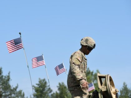 A US soldier stands at a tank type "M1A2 SEP" which are decorated with US flags at a parking position at the training area in Grafenwoehr, near Eschenbach, southern Germany, on May 11, 2016, during the exercise "Strong Europe Tank Challenge 2016". The exercise is the first Europe-wide tank challenge …