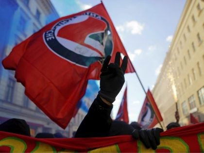 BERLIN, GERMANY - MAY 01: A demonstrator waves a antifascist flag during the 'Revolutionary 1st of May' May Day protest in Kreuzberg district on May 1, 2017 in Berlin, Germany. May Day is a holiday in Germany traditionally dedicated to labor, with unions and political parties holding gatherings and rallies …
