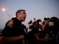 An official talks with protesters on Saturday, June 13, 2020, near the Atlanta Wendy's where Rayshard Brooks was shot and killed by police Friday evening following a struggle in the restaurant's drive-thru line in Atlanta. (AP Photo/Brynn Anderson)
