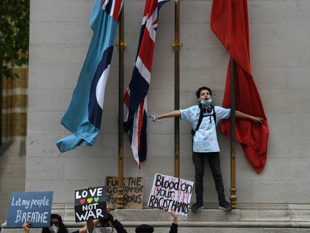 TOPSHOT - Protestors hold placards as they demonstrate by the Cenotaph war memorial on Whi