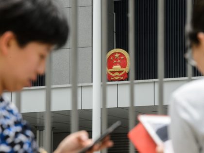 People use their phones to play the Pokemon Go app outside the Legislative Council offices in Hong Kong on July 26, 2016. The Chinese army garrisoned in Hong Kong has warned people searching for Pikachu and other virtual monsters to stay off their premises, as Pokemon Go mania sweeps the …