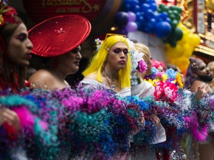 Drag queens hold a feather Boa, piled on the ground, during an attempt for a Guinness World Records Title for Longest Feather Boa at 1.2 Miles in celebration of World Pride at Time Square on June 20, 2019 in New York City. (Photo by Johannes EISELE / AFP) (Photo credit …