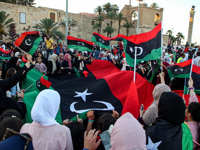 People celebrate with Libyan national flags, some clad in masks due to the COVID-19 coronavirus pandemic, in the capital Tripoli's Martyrs' Square on June 5, 2020, after fighters loyal to the UN-recognised Government of National Accord (GNA) captured the town of Tarhuna, about 65 kilometres southeast of the capital from …