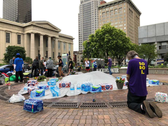 A man prays at Jefferson Square Park on Sunday, June 28, 2020, in Louisville, Ky., which h