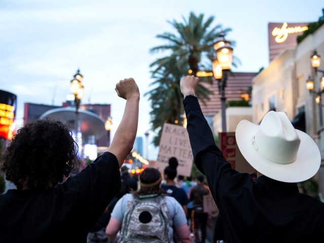 People shout slogans and hold placards, on June 1, 2020, in downtown Las Vegas, as they take part in a "Black lives matter" rally in response to the recent death of George Floyd, an unarmed black man who died while in police custody. - Thousands of National Guard troops patrolled …