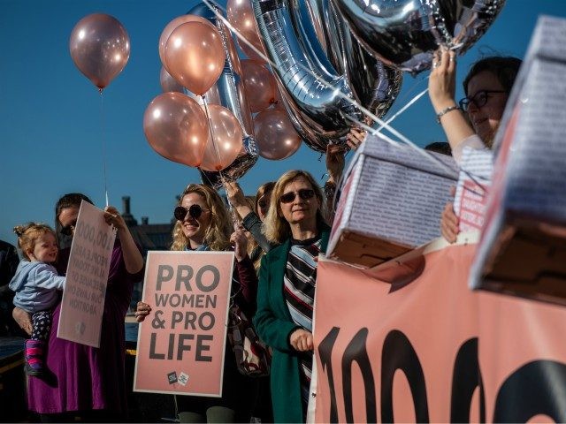LONDON, ENGLAND - FEBRUARY 26: Rebecca Morgan (L) and her daughter Helen, 1, join protesters supporting Northern Ireland's abortion laws at Parliament Square on February 26, 2019 in London, England. The protesters each held a box containing 10,000 names symbolising the 100,000 people who are alive today because of Northern …