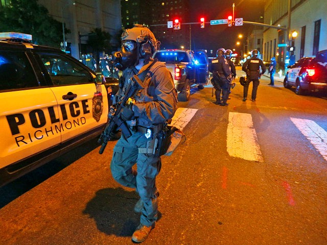 Police in riot gear prepare to disperse a group of protesters as they march through downtown for a third night of unrest Sunday May 31, 2020, in Richmond, Va. Gov. Ralph Northam issued a curfew for this evening. (AP Photo/Steve Helber)