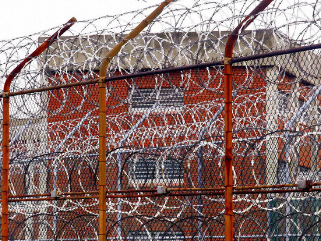 In this March 16, 2011, file photo, a security fence surrounds inmate housing on the Rikers Island correctional facility in New York. Health experts say prisons and jails are considered a potential epicenter for America’s coronavirus pandemic. (AP Photo/Bebeto Matthews, File)