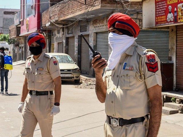 Police personnel stand guard as they close a street near the location of the residence of Sikh spiritual singer Nirmal Singh Khalsa, who died of the coronavirus after being tested positive, during a government-imposed nationwide lockdown as a preventive measure against the COVID-19 coronavirus, in Amritsar on April 2, 2020. (Photo by …