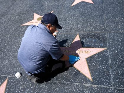 A maintenance worker uses cleaning product to remove graffiti after Donald Trump's star on the Hollywood Walk of Fame was defaced, in a mostly empty Hollywood, California, April 23, 2020, during the coronavirus COVID-19 pandemic. (Photo by Robyn Beck / AFP) (Photo by ROBYN BECK/AFP via Getty Images)