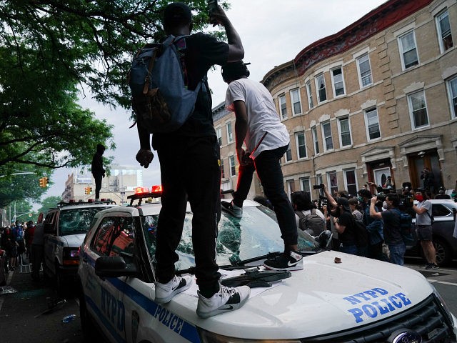 Protesters jump on an NYPD police SUV during a demonstration against the killing of George
