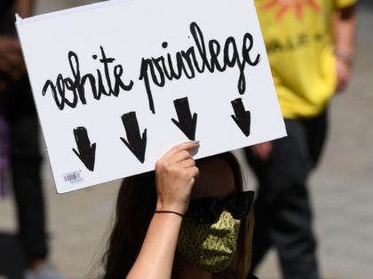 A woman holds a placard reading "White privilege" during a demonstration on June 14, 2020, in Barcelona, as part of the worldwide protests against racism and police brutality. - The protests are part of a worldwide movement following the killing in the United States of African-American man George Floyd who …