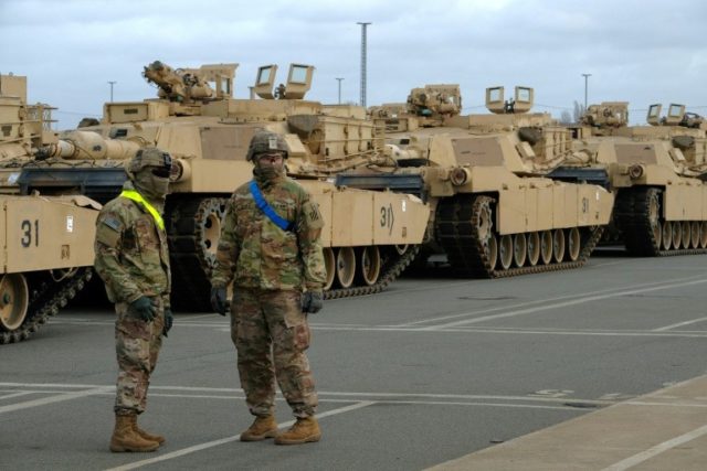 Military personnel unload M1 Abrams Fighting tanks of the 2nd Brigade Combat Team, 3rd Inf