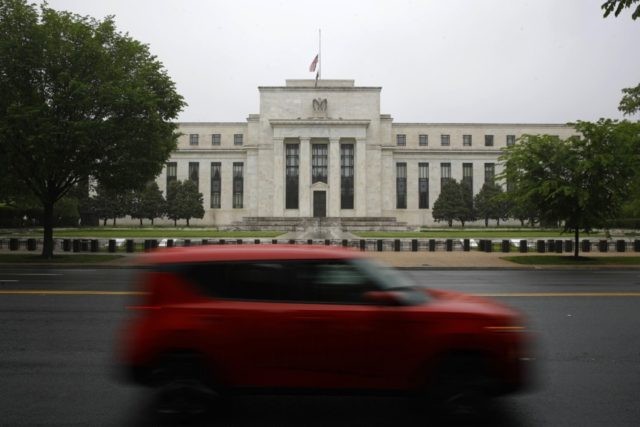 In this May 22, 2020, file photo, a car drives past the Federal Reserve building in Washington. The Federal Reserve on Sunday, June 28, 2020, released a list of roughly 750 companies, including Apple, Walmart, and ExxonMobil, whose corporate bonds it will purchase in the coming months in an effort …