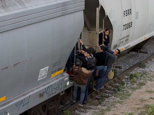 Migrants jump on train to cross U.S. Border. (AP File Photo/Eduardo Verdugo)
