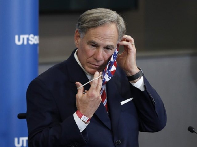Texas Gov. Greg Abbott puts on a mask after a news conference following a meeting between Vice President Mike Pence, Abbott and members of his healthcare team regarding COVID-19 at the University of Texas Southwestern Medical Center West Campus in Dallas, Sunday, June 28, 2020. (AP Photo/Tony Gutierrez)