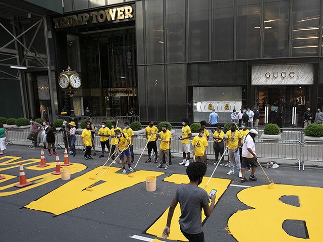 Volunteers paint Black Lives Matter on Fifth Avenue in front of Trump Tower, Thursday, July 9, 2020, in New York. (AP Photo/Mark Lennihan)