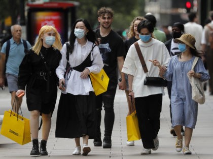 Shoppers wear face coverings to protect themselves from COVID-19 as they walk along Oxford Street in London, Friday, July 24, 2020. New rules on wearing masks in England have come into force, with people going to shops, banks and supermarkets now required to wear face coverings. Police can hand out …
