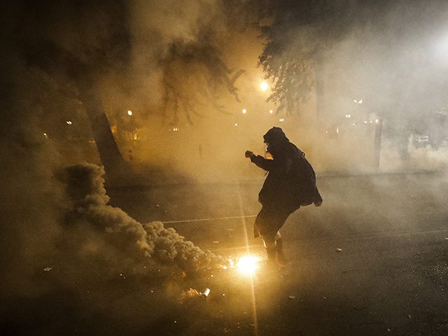 A demonstrator kicks back a tear gas canister back at federal officers during a Black Lives Matter protest at the Mark O. Hatfield United States Courthouse Wednesday, July 29, 2020, in Portland, Ore. (AP Photo/Marcio Jose Sanchez)