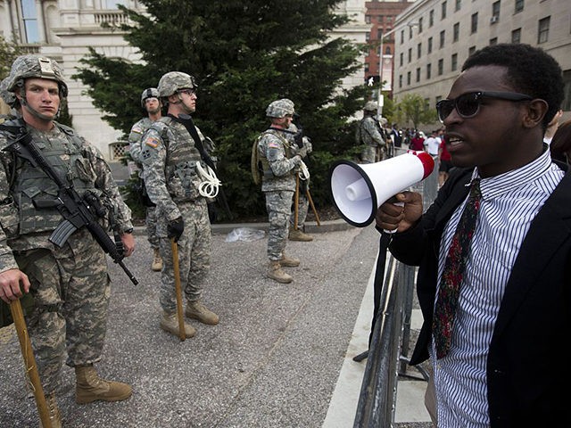 A protester talks with National Guard soldiers during a protest through Baltimore, Marylan