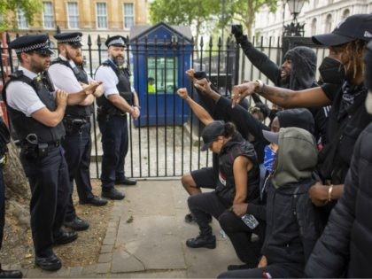 LONDON, ENGLAND - JUNE 03: People kneel in front of police during a Black Lives Matter protest at Hyde Park on June 03, 2020 in London, England. The death of an African-American man, George Floyd, while in the custody of Minneapolis police has sparked protests across the United States, as …