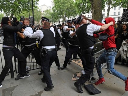 TOPSHOT - Protestors scuffle with Police officers near the entrance to Downing Street, dur