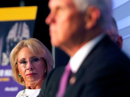 NAACP Education Secretary Betsy DeVos listens as Vice President Mike Pence speaks at a rou