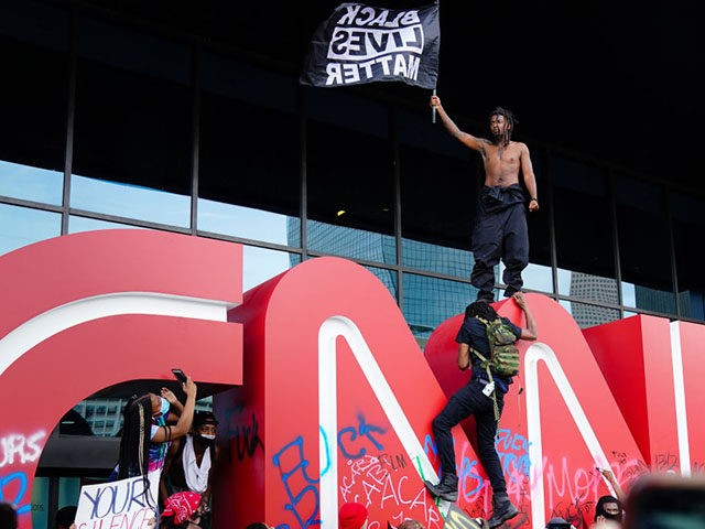 ATLANTA, GA - MAY 29: A man waves a Black Lives Matter flag atop the CNN logo during a pro