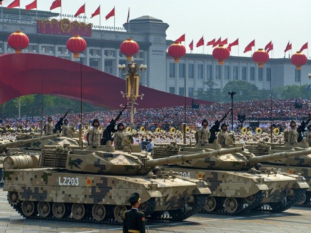 BEIJING, CHINA - OCTOBER 01: Chinese soldiers sit atop tanks as they drive in a parade to