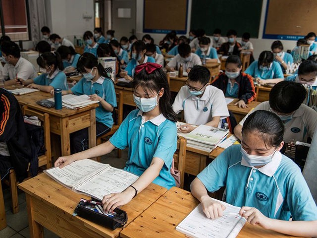 Students wear face masks as they study in a classroom in a high school in Wuhan in China's