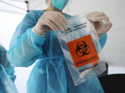 LOS ANGELES, CALIFORNIA - JULY 15: A nurse seals a specimen bag containing a COVID-19 test