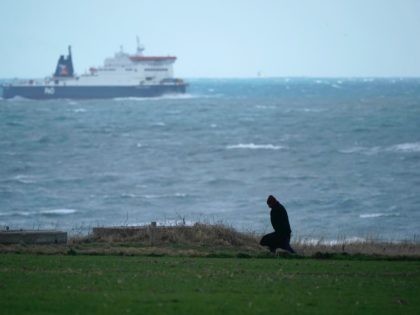 CALAIS, FRANCE - JANUARY 09: A person walks along the coastal footpath at Sangatte as a cross channel ferry makes its way to Calais January 09, 2019 in Calais, France. In recent weeks there has been an increase in migrants, many claiming to be from Iran, making the sea crossing …